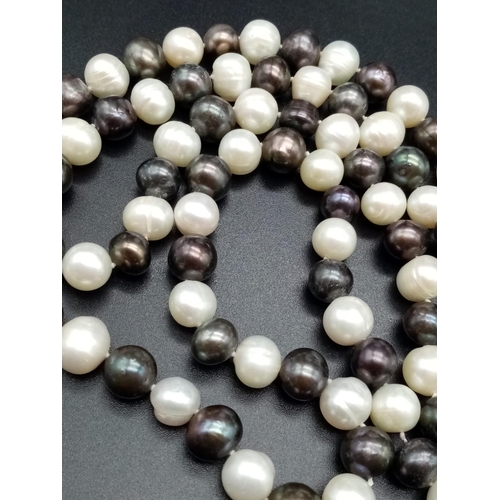 559 - An elegant and very long white and black pearl necklace  82cm long