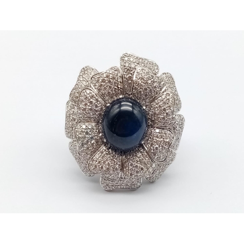 44 - an 18k white gold ring with a large saphire centre stone surrounded by individual diamond encrusted ... 