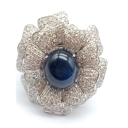 44 - an 18k white gold ring with a large saphire centre stone surrounded by individual diamond encrusted ... 