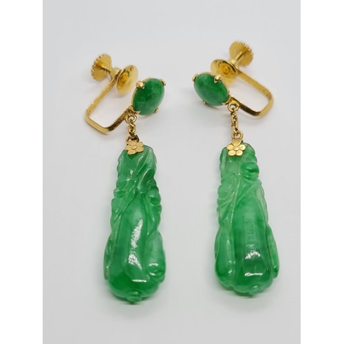 80 - Pair of 21k yellow Oriental gold earrings with natural carved Jade, weight 6.16g and 4cm drop approx