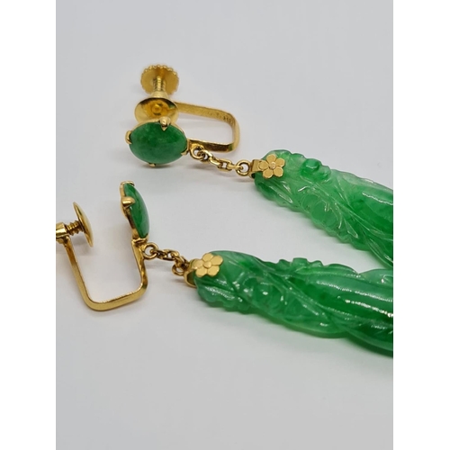 80 - Pair of 21k yellow Oriental gold earrings with natural carved Jade, weight 6.16g and 4cm drop approx