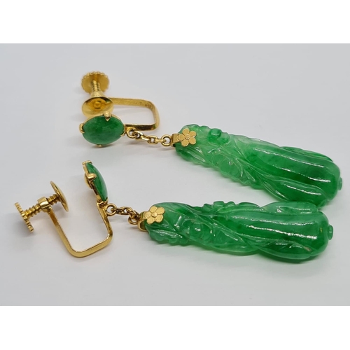 80 - Pair of 21k yellow Oriental gold earrings with natural carved Jade, weight 6.16g and 4cm drop approx