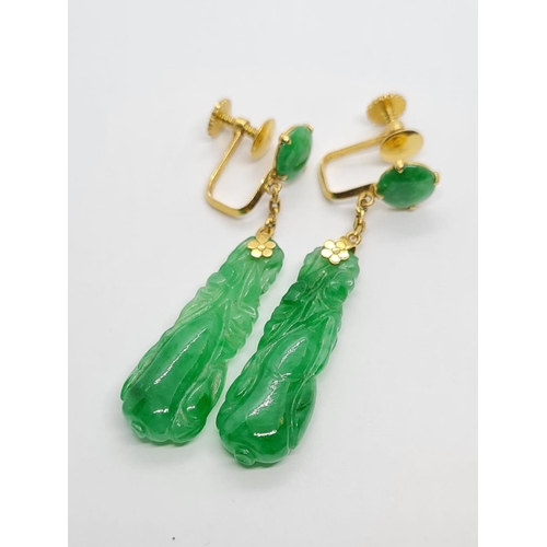 80 - Pair of 21k yellow Oriental gold earrings with natural carved Jade, weight 6.16g and 4cm drop approx