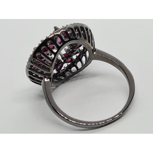 947 - Black 925 Sterling Silver Ring set with Marquise Cut Rubies. Size P.