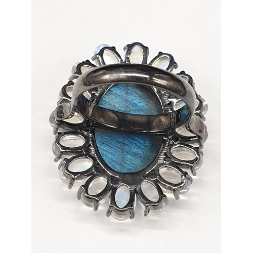 914 - 10.50 Ct Moonstones & 14.25 Ct Labradorite set within a blackened silver ring, weight 11.62g and siz... 