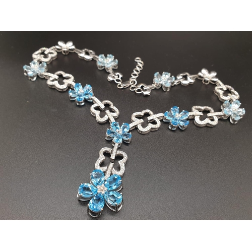 306 - AN 18K WHITE GOLD NECKLACE WITH DIAMOND, ACQUA MARINE AND TOPAZ STONES FASHIONED INTO A FLORAL DESIG... 