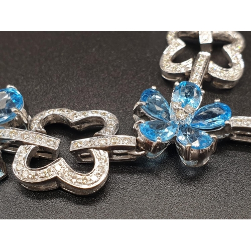 306 - AN 18K WHITE GOLD NECKLACE WITH DIAMOND, ACQUA MARINE AND TOPAZ STONES FASHIONED INTO A FLORAL DESIG... 