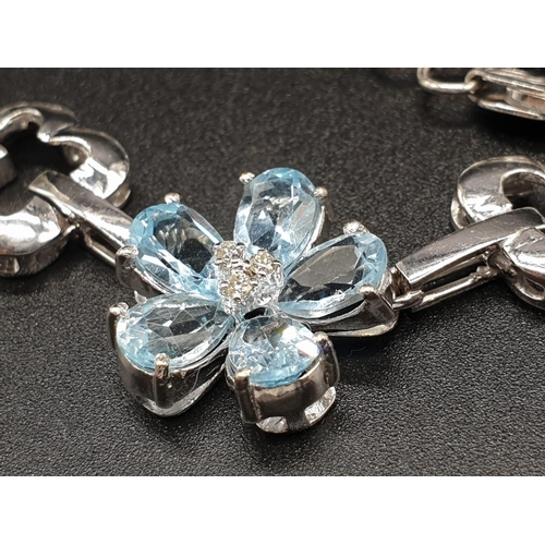 306 - AN 18K WHITE GOLD NECKLACE WITH DIAMOND, ACQUA MARINE AND TOPAZ STONES FASHIONED INTO A FLORAL DESIG... 