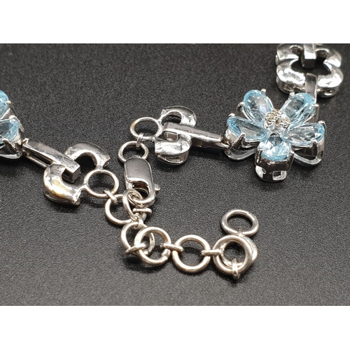 306 - AN 18K WHITE GOLD NECKLACE WITH DIAMOND, ACQUA MARINE AND TOPAZ STONES FASHIONED INTO A FLORAL DESIG... 