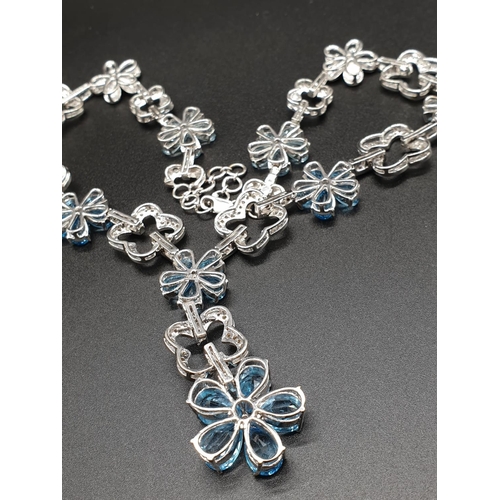 306 - AN 18K WHITE GOLD NECKLACE WITH DIAMOND, ACQUA MARINE AND TOPAZ STONES FASHIONED INTO A FLORAL DESIG... 