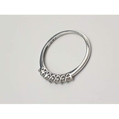 355 - 9K White Gold Diamond Set Seven-Stone Ring. 
0.2 Carat. 1.3g. Size O