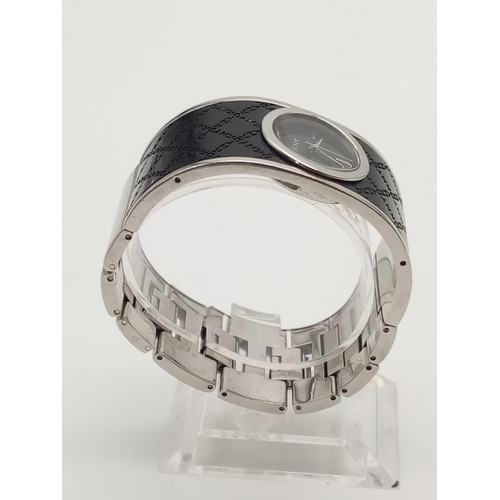 317 - DKNY Ladies Dress Watch. Black Monogramed Leather on Stainless Steel Strap. Black Dial. As found.
