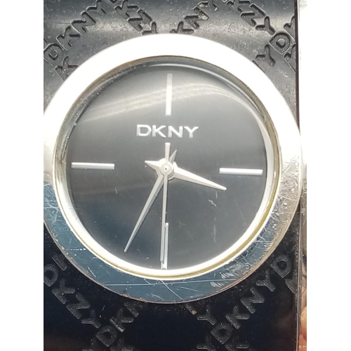 317 - DKNY Ladies Dress Watch. Black Monogramed Leather on Stainless Steel Strap. Black Dial. As found.