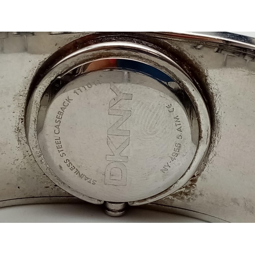 317 - DKNY Ladies Dress Watch. Black Monogramed Leather on Stainless Steel Strap. Black Dial. As found.