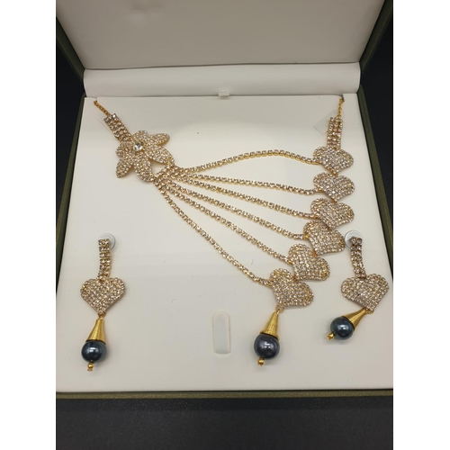 140 - A highly glamorous asymmetric necklace and matching earrings in a presentation box. With glittering ... 