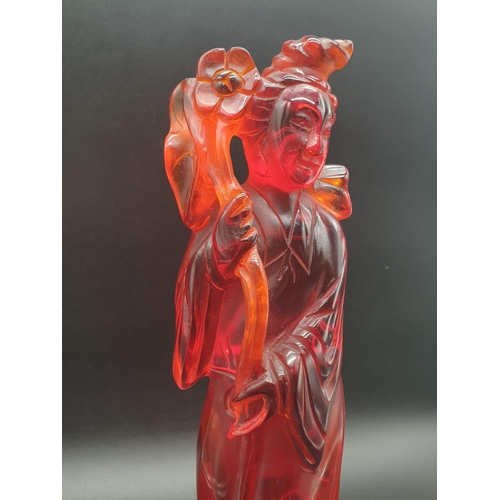 168 - A traditional, Chinese, hand carved, amber resin, statue of a lady holding an oversized flower, on a... 