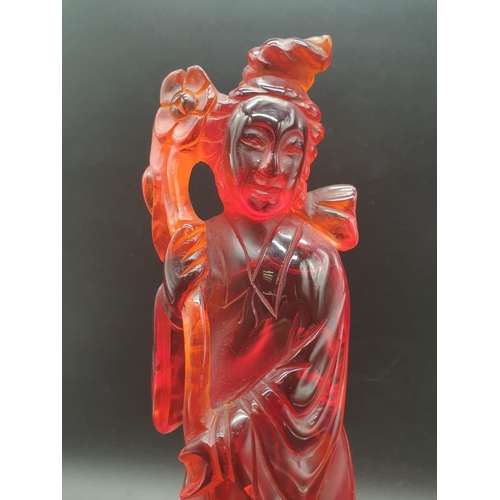 168 - A traditional, Chinese, hand carved, amber resin, statue of a lady holding an oversized flower, on a... 