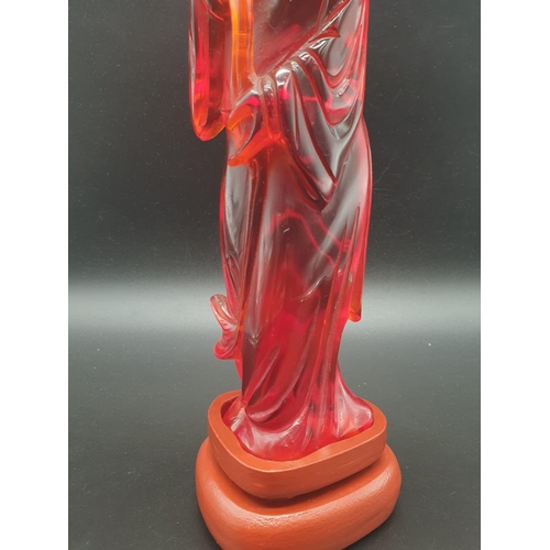 168 - A traditional, Chinese, hand carved, amber resin, statue of a lady holding an oversized flower, on a... 