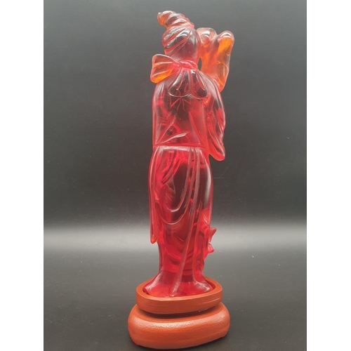 168 - A traditional, Chinese, hand carved, amber resin, statue of a lady holding an oversized flower, on a... 