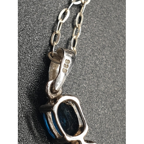 182 - A sterling silver (hallmarked) set of a pendant and matching ring with three faceted, oval, blue sap... 