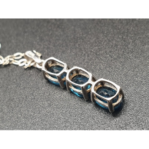 182 - A sterling silver (hallmarked) set of a pendant and matching ring with three faceted, oval, blue sap... 