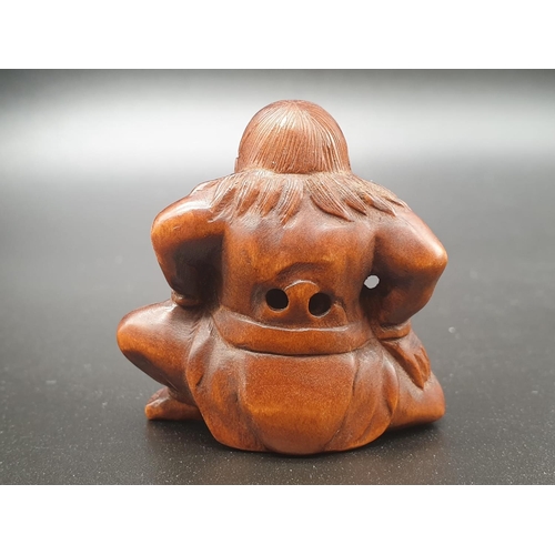 196 - An intricately carved boxwood netsuke of a Sumo wrestler on a ceremonial pose. Signed at the bottom ... 