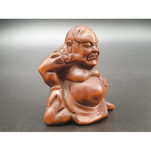 196 - An intricately carved boxwood netsuke of a Sumo wrestler on a ceremonial pose. Signed at the bottom ... 