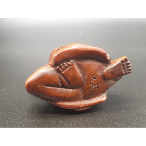 196 - An intricately carved boxwood netsuke of a Sumo wrestler on a ceremonial pose. Signed at the bottom ... 