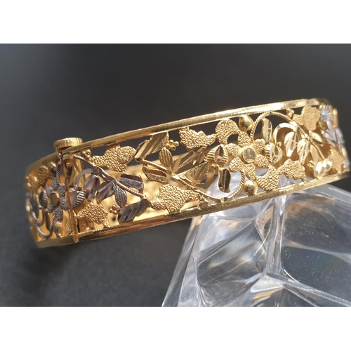 83 - A platinum (900) bangle with intricate white and yellow flower on vines design. A screw top clasp al... 