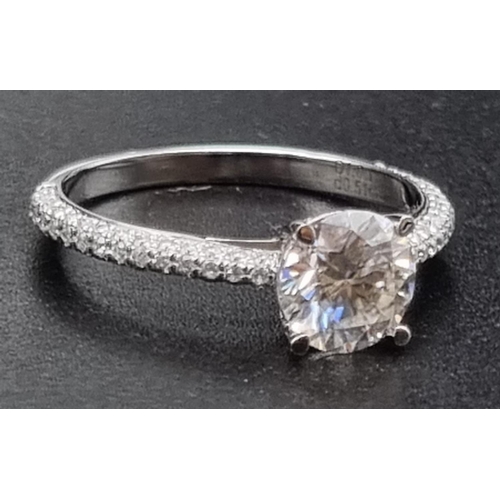 109 - An 18K White Gold Moissanite Centre-Stone Ring. Moissanite clusters on shoulders. Size N. 2.35g