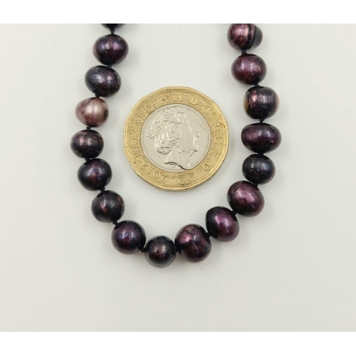 144 - A Two-Strand Cultured Purple Pearl Necklace. 120cm