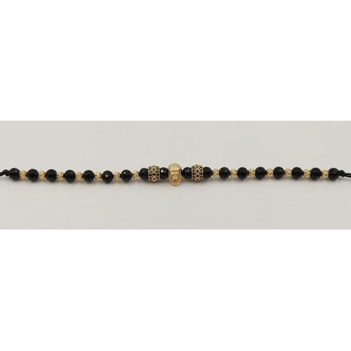 243 - 10k yellow gold and black stoned rope bracelet, featuring a gold monkey head to centre. length 29cm,... 