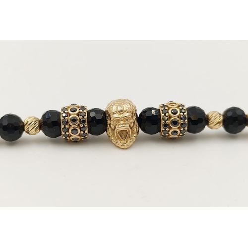 243 - 10k yellow gold and black stoned rope bracelet, featuring a gold monkey head to centre. length 29cm,... 