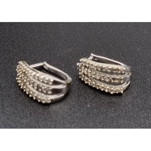 383 - A Pair of 10K White Gold Diamond Earrings. Three strands of diamonds on each earring. 2.86g