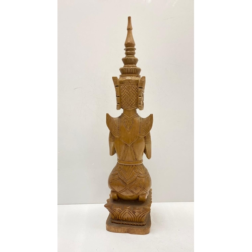 340 - Tall wood carving art of Thai Buddha figure, kneeling in prayer. 57cm in height.