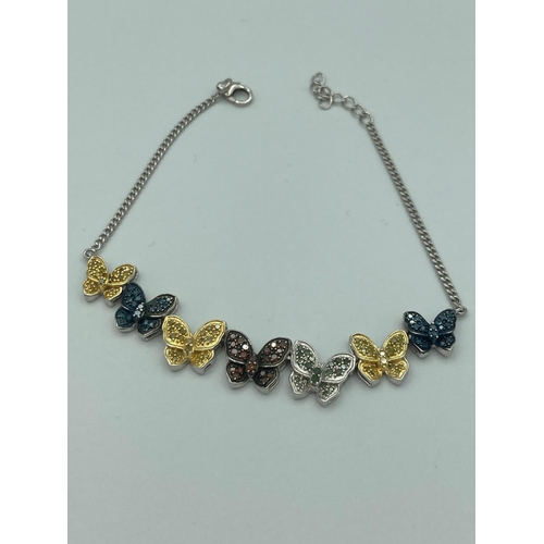 77 - SILVER and DIAMOND BUTTERFLY BRACELET  having seven centred butterflies set with coloured diamonds,a... 