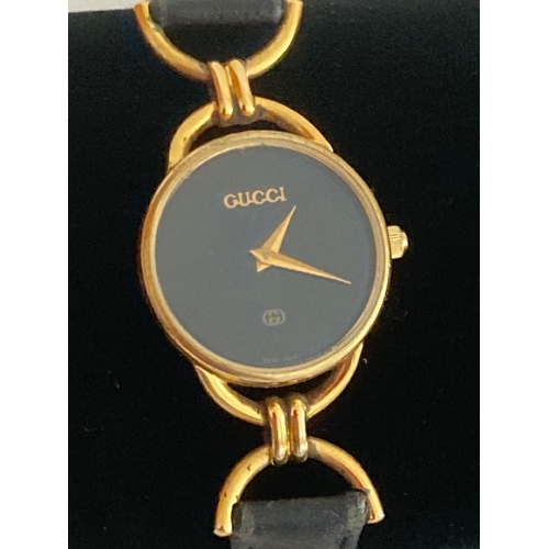 114 - Ladies Quartz wristwatch having black face with marking showing Gucci. Watch case showing serial num... 