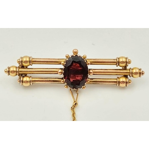 87 - A Vintage 9K Yellow Gold Three-Bar Garnet Brooch.
5cm. 4.47g.