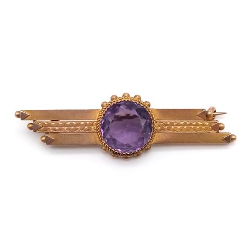 760 - A 9 K yellow gold brooch with a round cut amethyst. Length: 4.6 cm, weight: 3.3 g.