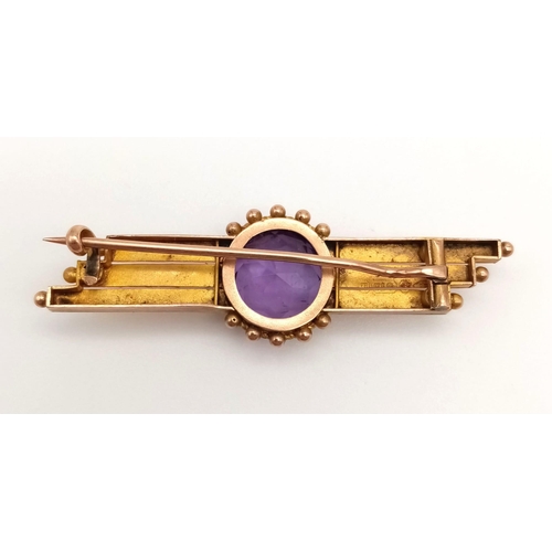 760 - A 9 K yellow gold brooch with a round cut amethyst. Length: 4.6 cm, weight: 3.3 g.