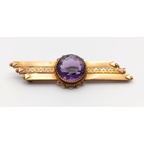 760 - A 9 K yellow gold brooch with a round cut amethyst. Length: 4.6 cm, weight: 3.3 g.