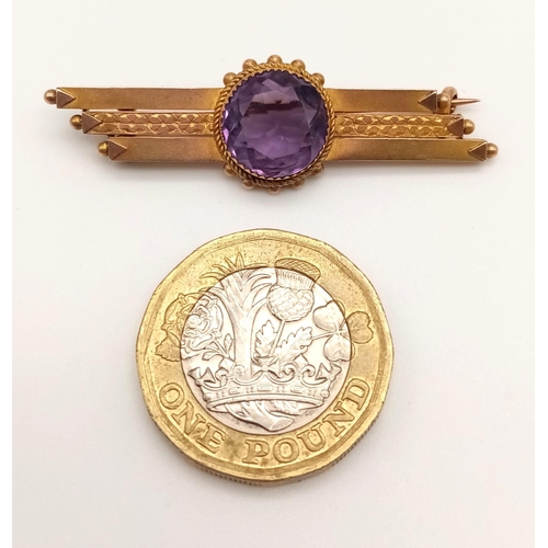 760 - A 9 K yellow gold brooch with a round cut amethyst. Length: 4.6 cm, weight: 3.3 g.