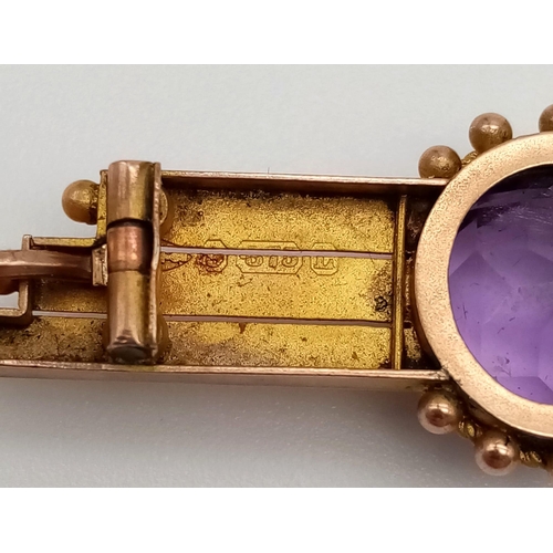 760 - A 9 K yellow gold brooch with a round cut amethyst. Length: 4.6 cm, weight: 3.3 g.