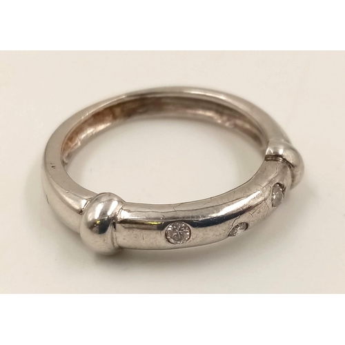 753 - An 18K White Gold Three Diamond Ring. Size M.
3.8g.