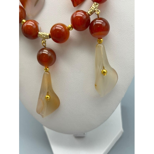 50 - A beautiful, banded, orange agate necklace and earrings set with hand carved lilies. Necklace length... 