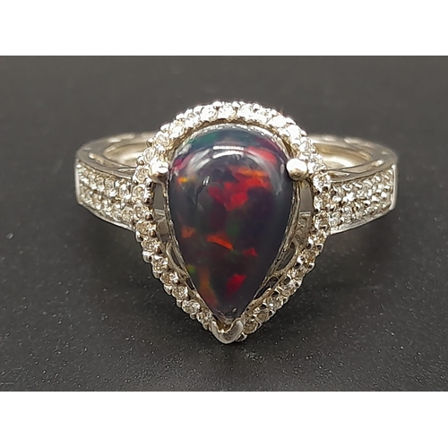 751 - A Stunning 18K White Gold Black Opal and Diamond Ring. Teardrop shaped black opal surrounded by a te... 