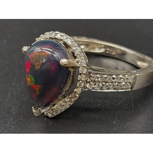 751 - A Stunning 18K White Gold Black Opal and Diamond Ring. Teardrop shaped black opal surrounded by a te... 