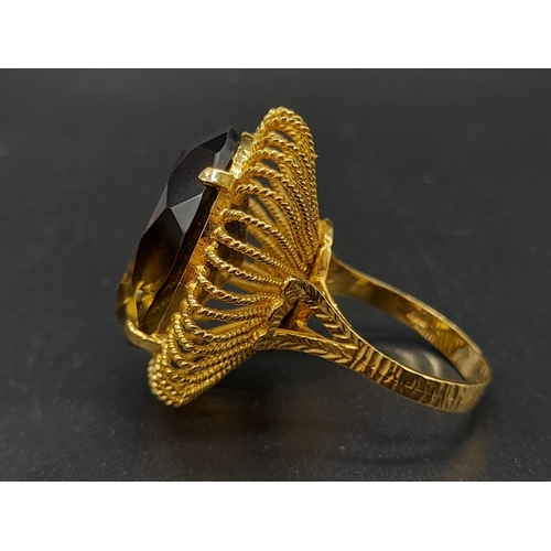 31 - An 18 K yellow gold ring with a massive, oval cut, smoky quartz. Ring size: R, weight: 12.73 g.