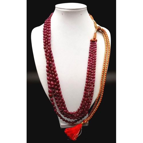 749 - A 500cts , Five row cabochon tear drop shaped ruby gemstone necklace with traditional Indian Textile... 