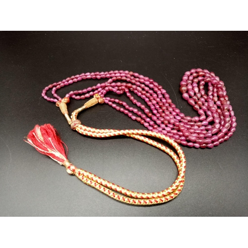 749 - A 500cts , Five row cabochon tear drop shaped ruby gemstone necklace with traditional Indian Textile... 